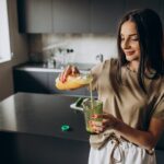 young-woman-drinking-juice-home_1303-24177