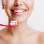 girl-with-sincere-smile-makes-morning-routine-brushes-her-teeth-isolated-wall_197531-13926