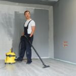 A,Worker,Using,A,Vacuum,Cleaner,Removes,Construction,Debris.,A