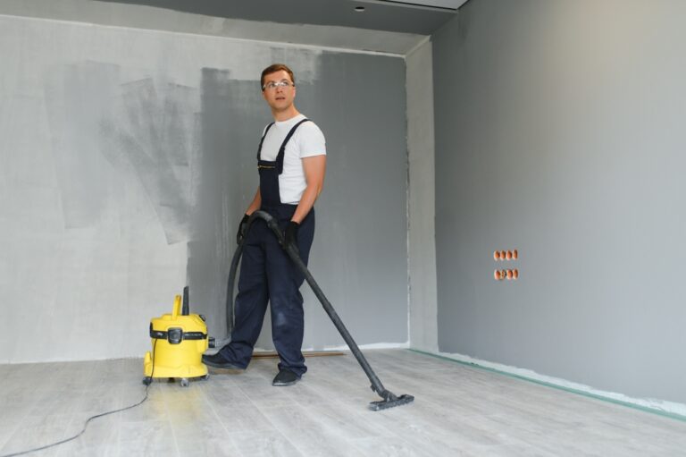 A,Worker,Using,A,Vacuum,Cleaner,Removes,Construction,Debris.,A