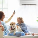 Mother,And,Child,With,Air,Conditioner,Remote,Control.,Comfortable,Temperature