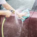Man washing car using spray jet water - home people car clean concept