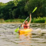 young-man-paddling-kayak-with-lots-splashes-lake_23-2147870291