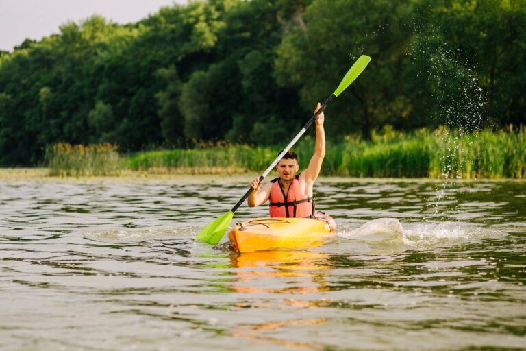 young-man-paddling-kayak-with-lots-splashes-lake_23-2147870291
