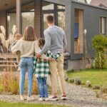 back-view-family-hugging-admiring-their-home_259150-59357